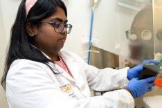 Student wearing lab coat in research lab