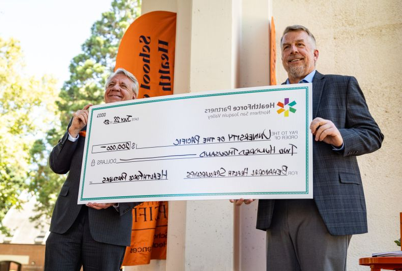 paul lanning and christopher callahan holding check at presentation