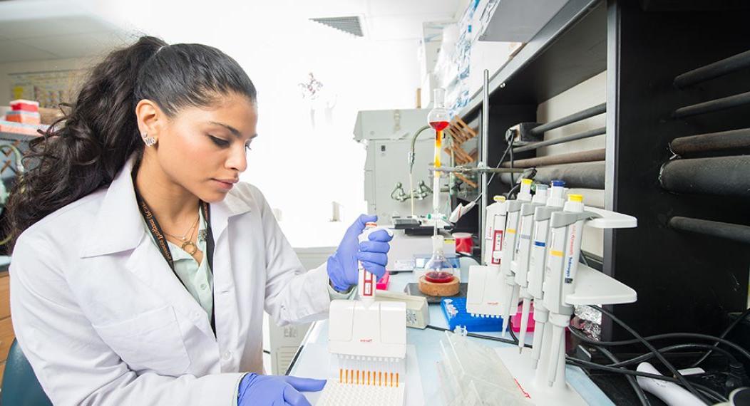 Student doing research holding a micropipette